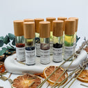 Set of small bottles with bamboo caps on a decorative stand with dried herbs and plants.