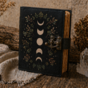 Decorative black notebook with moon phase design on a rustic background