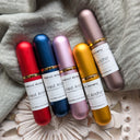 Five small bottles of Rest And Renew Alchemy on a textured surface