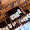 Wooden drawer with essential oil bottles with a blurred blue background.