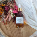 Bottle of Wildroot Alchemy Valerian Bloom on a wooden surface with dried flowers.