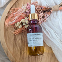 Bottle of Wildroot Alchemy Elixir of Moorvel on a wooden surface with dried flowers.
