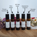 Five small bottles of essential oil blends on a wooden surface with labels indicating their uses.