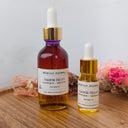 Two bottles of Wildroot Alchemy Valerian Bloom on a wooden surface with a neutral background.