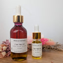 Two bottles of Wildroot Alchemy Fae Nectar on a wooden surface with a neutral background.
