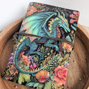 Colorful dragon and floral design notebook on a wooden surface