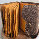 Leather-bound book with embossed design on a wooden stand