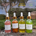 Four bottles of Wildroot Alchemy oils with labels and descriptions on a natural background.